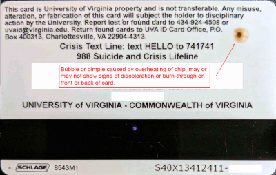 Image of the back of a UVA ID card showing and overheated chip. Arrow pointing to the chip with note: "Bubble or dimple caused by overheating of chip, may or many not show signs of discoloration or burn-through on front or back of card. 